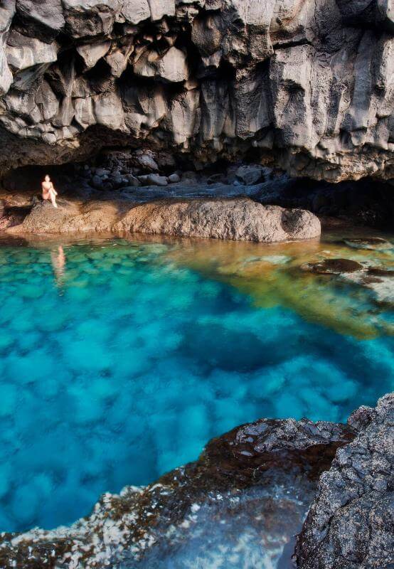Charco Azul de El Hierro, uma lagoa natural de águas turquesas rodeada de rocha vulcânica sob uma falésia.