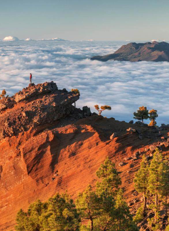 A Punta de Los Roques em La Palma, com cristas vulcânicas iluminadas, mar de nuvens e pinhal canário.